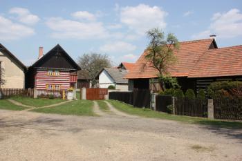 Severovýchodní kout návsi s obytným stavením usedlosti čp. 12 (vlevo) a hospodářskými budovami usedlosti čp. 13  ( © Ivan Grisa 04/2011)