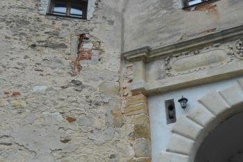 Detail rohu renesanční brány s otvorem pro kladku a zazděným okénkem (či jen druhotně zazděnými kamenickými články) (© Jan Večeřa, 07/2015)