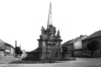 pilíř v původním umístění na kralupské návsi (© Oblastní muzeum v Chomutově (fotorepro kol.: Mariánské, trojiční a další světecké sloupy a pilíře v Ústeckém kraji, Národní památkový ústav, Praha 2012))