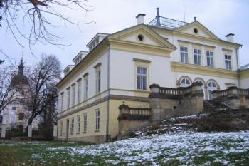 Zámecká budova z parku, v pozadí kostel sv. Klimenta ( © Pavel Vítek 11/2005)