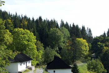 Kalište - v popředí základy vypálených domů, vzadu zrekonstuované domky s expozicí (© Radoslav Malovec, 10/2013)