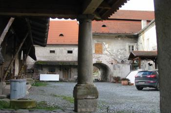 vpravo od sloupu barokní část zámku,vlevo zchátralá renesanční část, vzadu průjezd do dvora (© D Dohňanský, 12/2014)