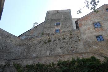Pohled z 2. předhradí na západní hranolovou věž, v hradbě před ní zazděné otvory (střílny) (© Jan Večeřa, 07/2015)