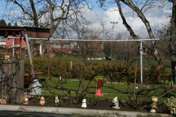 Pohled na tvrziště přes plot zahrady (© Petr Nožička 04/2015)