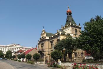 Celkový pohled na vilu z Komenského ulice, v pozadí Základní škola v Kozelkově ulici (© Pavel  Vlach, 08/2015)