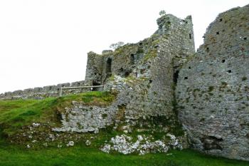 Pohled z přízemí pod bývalým velkým sálem na dvouvěžový branský dům.  Na popředí je torzo jižní boční zdi domu. (© Pavel Semple, 08/2015)