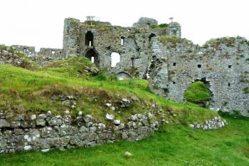 Pohled přes vnitřní prostor hradu na dvouvěžový branský dům.  Na popředí je zeď terasy. (© Pavel Semple, 08/2015)