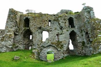 Vnitřní strana východního průčelí dvouvěžového branského domu (při pohledu od západu).  Uprostřed je portál brány.  Po obou stranách průjezdu byly valeně klenuté místnosti.  Věže jsou plné takže se v interiéru domu neprojevují. (© Pavel Semple, 08/2015)