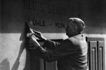 mlynář Alois Ševčík odstraňuje v roce 1945 z mlýna německý nápis (© Státní okresní archiv ve Frýdku-Místku)