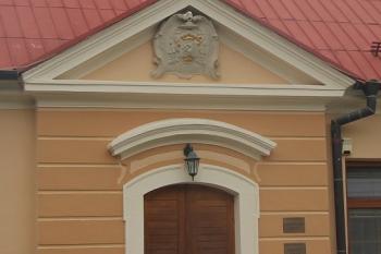 V tympanonu nad vchodem do fary je erb nitranského biskupa Antona Révaie (© Luděk Vláčil 06/2018)