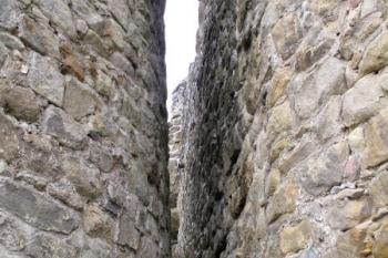 úzký prostor mezi hradbou horního hradu (mladšího paláce - vpravo) a studniční věže (vlevo) ( © Jan P. Štěpánek 04/2013)