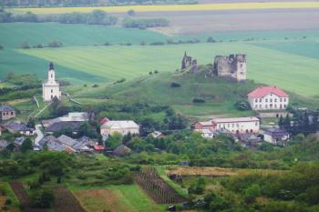 Pohled na Veľký Kamenec od západu. Nalevo stojí farní kostel z 18. stol. Napravo pod hradem je zámek z 19. stol. (© Pavel Semple 04/2019)