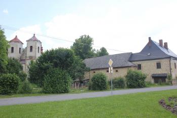 Ke kostelu patří fara s hospodářskými přístavbami. (© Luděk Vláčil 07/2020)