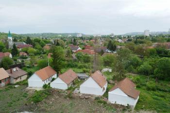 Pohled z hradu k východu, směrem na Miškovec. Domky na popředí zasahovaly do hradního příkopu. Byly vykoupeny a na straně hradu ubourány. Zasypaná východní část příkopu pak byla vybagrovaná. (© Pavel Semple 04/2019)