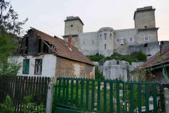 Domky na popředí zasahovaly do hradního příkopu. Byly vykoupeny a na straně hradu ubourány. Zasypaná východní část příkopu pak byla vybagrovaná. (© Pavel Semple 04/2019)