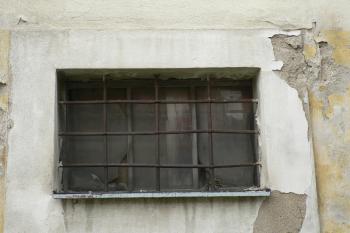 Detail autentické kované, pravoúhle provlékané, mříže kryjící jedno z oken S průčelí. (© Ondřej Drlík, 02/2012)