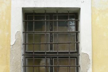 Autentická pravoúhle provlékaná mříž kryjící jedno z oken S průčelí. (© Ondřej Drlík, 02/2012)