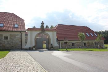 Památkově chráněná barokní brána, za níž je budova tvrze. (© Luděk Vláčil  08/2021)