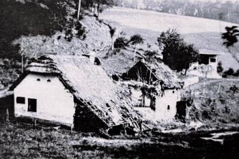 Poničená chalupa rodiny Záhorských (© Fotorepro z cedule u místa 40.léta 20. století)
