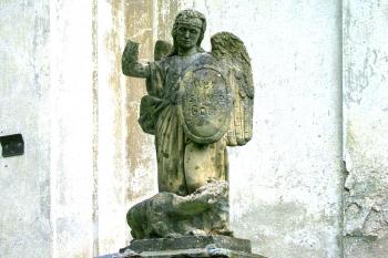 Socha anděla u vchodu do kostela sv. Jana Nepomuckého ve Skuhrově. (© Pavel Vítek  09/2023)