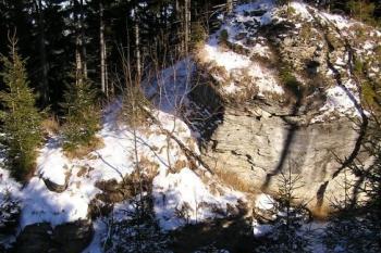 Pohled z místa zanikajícího čelní valu na mohutné skalisko v čele přední části hradu (© Jan P. Štěpánek, 12/2006)
