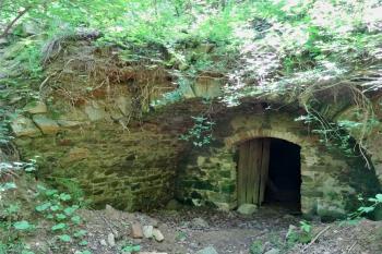 ústí vstupu do sklípku zasekaného do skály s torzem klenby navazující budovy (© Jan P. Štěpánek  04/2024)