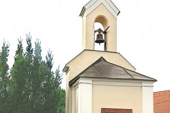 Tupadly se připomínají v 13. století. Kaplička pochází z 19. stol. Ve vitrínce současná polychromovaná soška sv. Jana Nepomuckého. Kaplička opravena poč. 21. století. (© Pavel Vítek 11/2023)