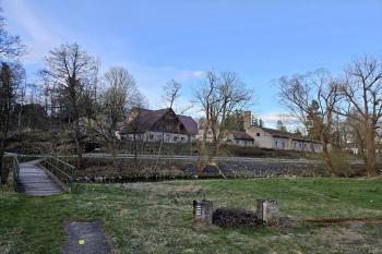 Celkový pohled na areál bývalé sklářské hutě i se skalním bradlem, které dalo pojmenování celé vesnici (© Jan P. Štěpánek  05/2024)