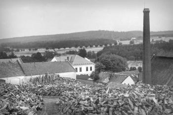 Sklářská huť, pohled na sklad dřeva, vpravo komín Vilemíniny huti (© Východočeské muzeum v Pardubicích)
