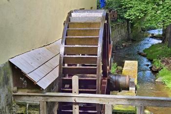 Pohled z mostku přes náhon na stavidla s obnoveným mlýnským kolem (© Jan P. Štěpánek  05/2024)