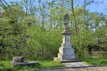 socha sv. Jana Nepomuckého ve Škrovádu s torzy mlýnských kamenů  (© Jan P. Štěpánek  04/2025)