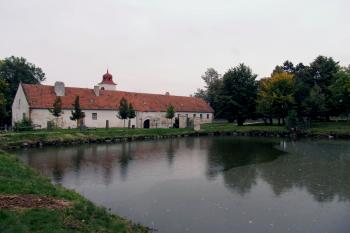 Pohled z parku přes rybník Pivovárek na hospodářské budovy v předzámčí. (© Pavel  Vlach, 09/2013)