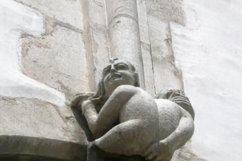 postavička panáčka nad oknem svatojakubského kostela vystrkujícího zadek směrem na katedrálu na Petrově ( © Jan P. Štěpánek 06/2008)