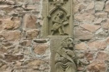Reliéf 1. brány, dole maskarón, výše sedící postava se šerpou (Jiří z Poděbrad?), ještě výše kameník pracující se špicplošinou (© Jan Večeřa, 05/2015)