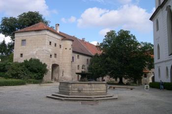 Bývalý dům opata (vlevo) a část západního průčelí kostela (vpravo) ( © Ivan Grisa 08/2005)