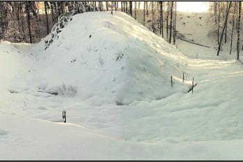 panoramatický pohled na kopcovité jádro hrádku obklopené mohutným příkopem - pohled z přístupové strany, od severu ( © Jan P. Štěpánek 01/2006)