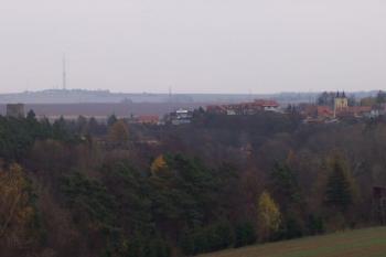 Otaslavice - Pohled na Otaslavice od Obrovy nohy. Vlevo je vidět věž dolního hradu, uprostřed na nejvyšším místě stával horní hrad, vpravo je vidět kostel. V pozadí se tyčí vysílač Dobrochov. (© Ivo Rozehnal, 11/2006)