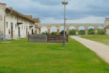 Vzadu ohradní arkádová zeď s pilíři spojující hosp. budovu /vlevo/ s bočním křídlem rotundy /vpravo (© Dušan Dohňanský  05/2021)