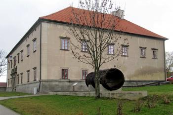 zámek od jihu - dnes je na zámku Obecní úřad - před úřadem část původního dřevěného potrubí, které přivádělo vodu do vodní elektrátny (© Rodochrozit        , 11/2013)