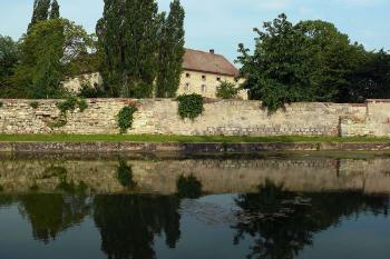 Pohled na zámek z návsi přes nádrž a ohradní zeď (© Jiří Cukr, 07/2013)