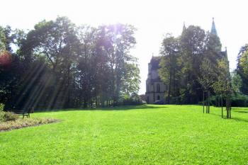 Pohled přes zatravněnou plochu na níž stával zaniklý zámek Orlová ke kostelu ( © Jan P. Štěpánek 09/2007)