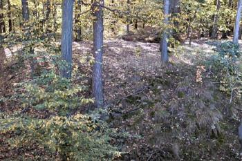 Okrouhlé jádro obklopené hlubokým příkopem. Pohled od západu. (© Peprník 10/2004)
