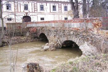 Jižní, zachovalejší strana kamenného obloukového mostu spojujícího areál zámků s kostelem. (© Jan P. Štěpánek, 04/2006)