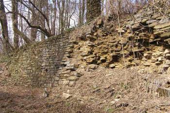 Pozůstatek kamenného obezdění vnitřní strany zemního valu (vnější strany příkopu) (© Jan P. Štěpánek, 04/2006)