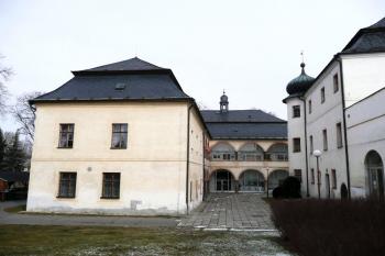 Nový zámek na půdoryse písmene L s arkádami a vpravo dvoupatrová budova starší tvrze ( © Jan P. Štěpánek 02/2008)