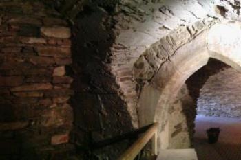 Panoramatické foto ze sklepení, gotický portál s vandalskými nápisy a s (pozdněgotickou?) pětibokou výsečí (© Jan Večeřa, 03/2015)