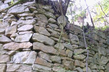 Detail zdění nároží hlavní hradby zvenčí, v horní části pouze k sobě přiložené kameny bez lepšího provázání, dole jsou patrné provazující kameny (© Jan Večeřa, 09/2014)