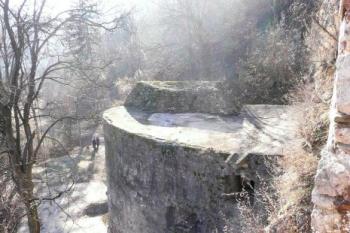 pohled z východního paláce jádra hradu na mohutnou baštu, která překryla tunel vylámaný ve skále  - jediný přístup do hradu ( © Jan P. Štěpánek 02/2008)