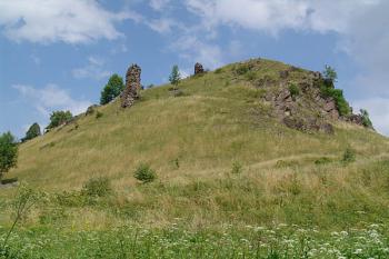 Pohled na hradní kopec od jihozápadu se zbytkem hranolové věže na úbočí ( © Roman Řezáč 08/2005)