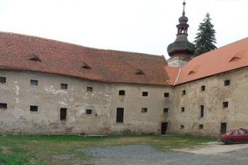 Panoramatický pohled na tvrz, v pozadí s kostelní věží. Východní křídlo má již opravenou střechu. ( © Filip Matoušek 07/2006)